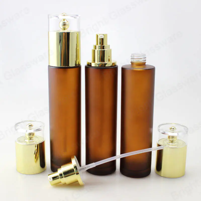 Botellas de lujo de 100 ml de loción de vidrio ámbar Botella de suero de bomba cosmética con tapa dorada