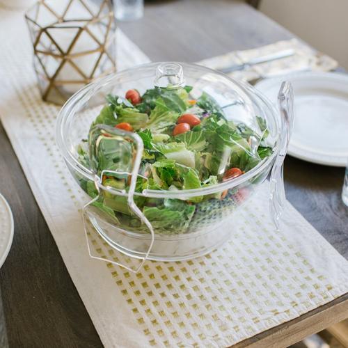 Chilled salad bowl on ice with spoon and fork 