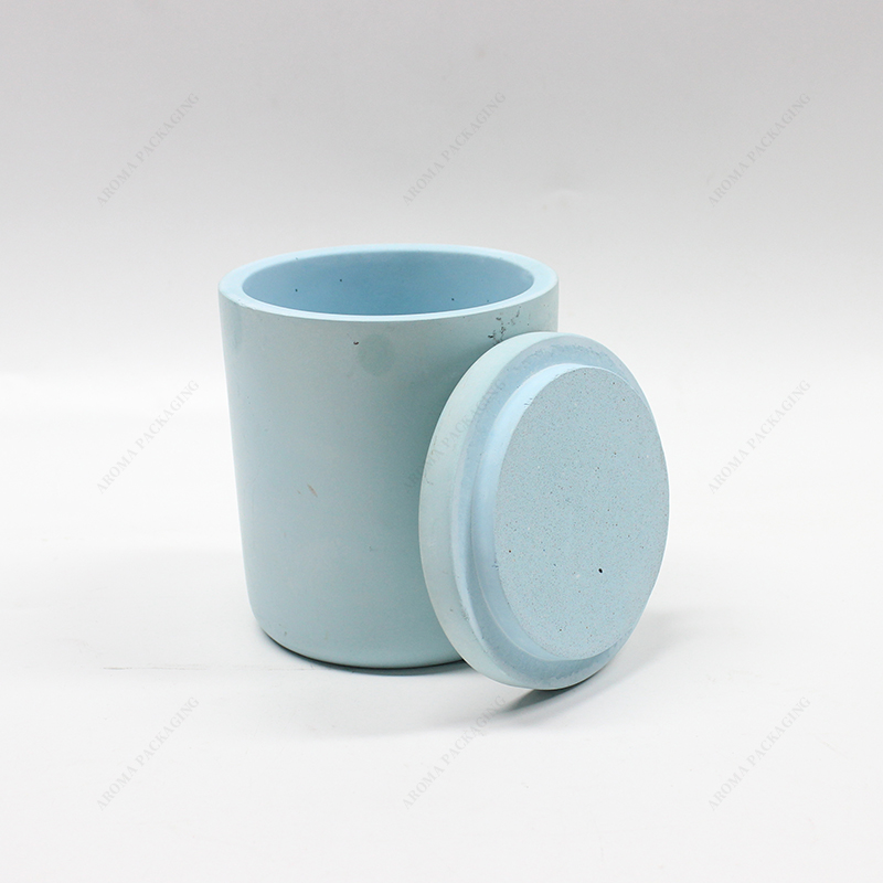 ふたが付いている円形の青いコンクリートの蝋燭の瓶