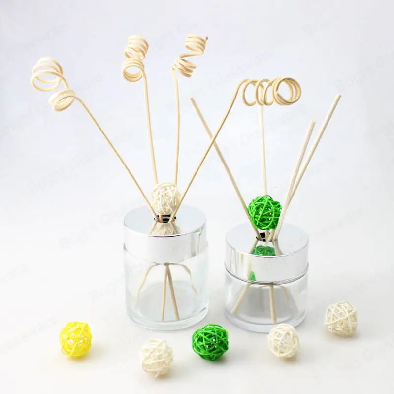 clear round glass fragrance diffuser bottle with silver screw top cap and rattan stick