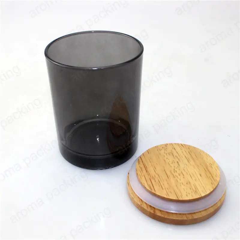 木製のふたが付いている蝋燭のための空の半透明の黒いガラス瓶
