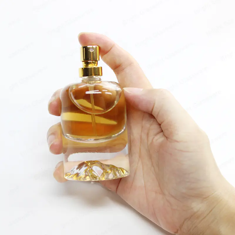 Venta al por mayor personalizada de la botella de aerosol de perfume de vidrio de base pesada con cabeza de pulverización de oro