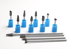 How do the cutting flutes of carbide burrs influence material removal rates and surface finish quality during machining operations